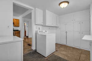 Laundry room off of kitchen with lots of storage, leading to utility room crawl space via in-ground trapdoor.
