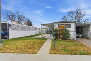 View of front of property with a front lawn and a carport