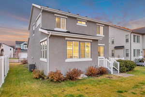 Back of property at dusk with stucco siding