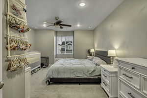 Bedroom featuring light colored carpet, a ceiling fan, and recessed lighting