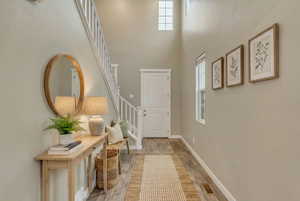 (VIRTUALLY STAGED) Entrance foyer with a high ceiling and wood finished floors