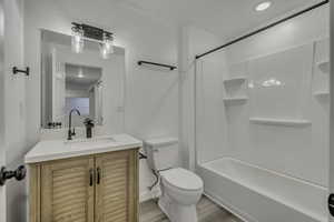 Full bath featuring vanity, shower / washtub combination, and light wood-style flooring
