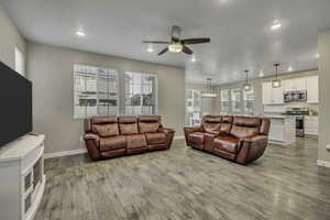 Living area featuring a ceiling fan, light wood-style flooring, and recessed lighting