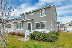 Traditional-style home featuring stucco siding and a front lawn