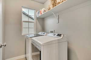 Laundry area with separate washer and dryer and baseboards