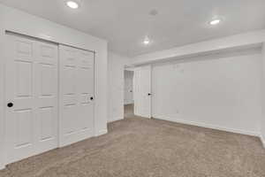 Unfurnished bedroom featuring carpet flooring, a closet, and recessed lighting