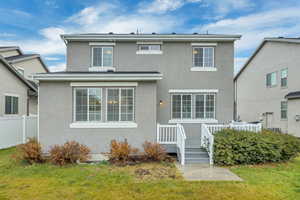 View of front facade featuring stucco siding and a wooden deck
