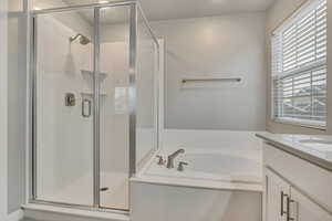 Full bathroom with vanity, a shower stall, and a garden tub