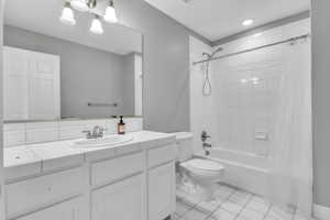 Bathroom with shower / tub combo, vanity, and light tile patterned floors