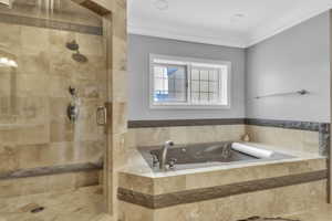 Full bath with crown molding, a bath, and a shower stall