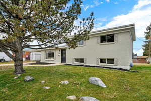 Tri-level home with a front yard and brick siding