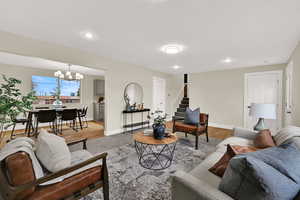 Living room featuring stairway, a chandelier, wood finished floors, recessed lighting, and a textured ceiling