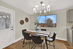 Dining room featuring light wood-type flooring and a chandelier