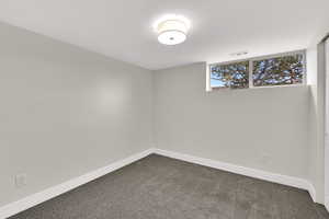 Empty room featuring carpet flooring and baseboards