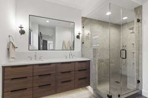 Full bathroom with double vanity, a stall shower, light tile patterned flooring, and recessed lighting