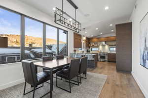 Dining space with lofted ceiling, recessed lighting, and light wood-type flooring