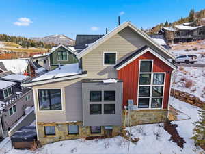 Snow covered property featuring stone siding and a mountain view