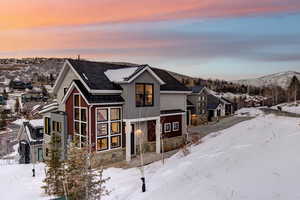 View of front facade featuring stone siding, a metal roof, a standing seam roof, and a mountain view