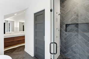 Bathroom featuring double vanity and a shower stall