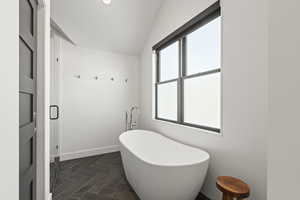 Bathroom with a freestanding tub and vaulted ceiling
