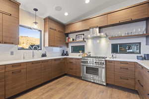 Kitchen featuring open shelves, high end stainless steel range oven, wall chimney range hood, decorative backsplash, and recessed lighting