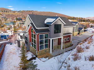 View of front of property with stone siding, a metal roof, a standing seam roof, a residential view, and roof with shingles