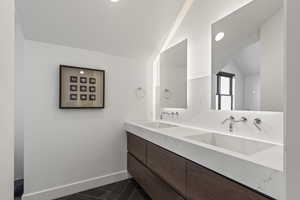 Full bathroom featuring double vanity, vaulted ceiling, and recessed lighting