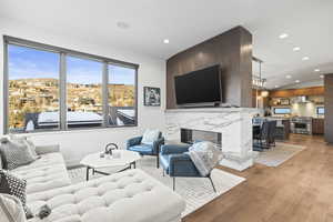 Living area with light wood-style floors, a fireplace, recessed lighting, and lofted ceiling