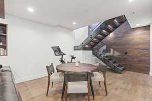 Dining room featuring light wood-type flooring, stairs, and recessed lighting