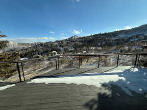 Snow covered deck with a mountain view