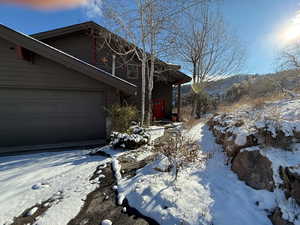 View of snow covered exterior featuring a garage