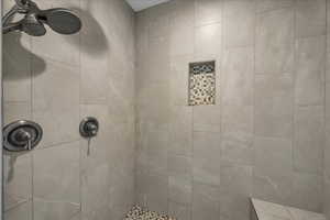 Full bath featuring tiled shower
