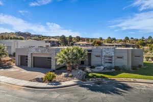 Contemporary house with stone siding, concrete driveway, and stucco siding