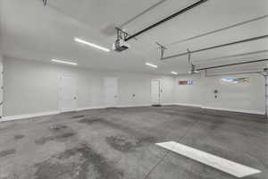 Garage featuring baseboards and a garage door opener