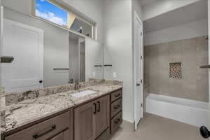 Bathroom featuring vanity, light tile patterned flooring, and  shower combination
