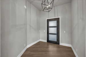 Foyer entrance with dark wood-type flooring and a chandelier