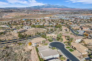 Aerial view of property and surrounding area with nearby suburban area and a mountain backdrop