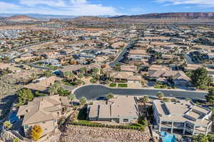 Aerial view of property and surrounding area featuring mountains and nearby suburban area