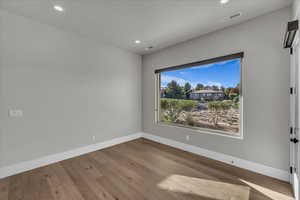 Empty room featuring wood-type flooring and recessed lighting
