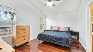 Bedroom featuring lofted ceiling, dark wood-style flooring, and ceiling fan