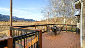 Wooden terrace featuring outdoor dining space and a mountain view