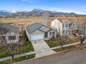 View of front facade featuring stucco siding, driveway, an attached garage, and a mountain view