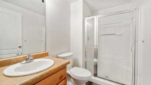 Full bathroom with a shower stall, vanity, and a textured ceiling