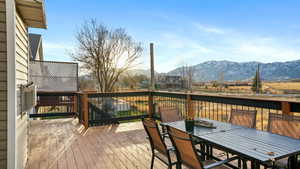 Wooden terrace featuring outdoor dining area and a mountain view