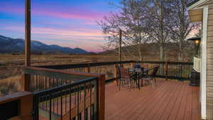 Deck with outdoor dining area and a mountain view