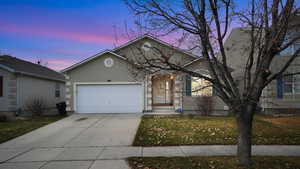 Single story home with concrete driveway, a front lawn, stucco siding, and a garage