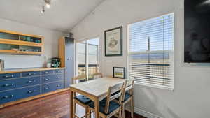 Dining space featuring lofted ceiling and dark wood-style flooring