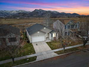 View of front of home with stucco siding, concrete driveway, an attached garage, and a mountain view