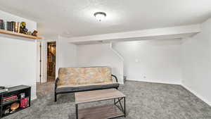 Living area featuring a textured ceiling and carpet