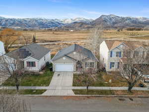 View of front of home with driveway, a mountain view, an attached garage, and a view of rural / pastoral area